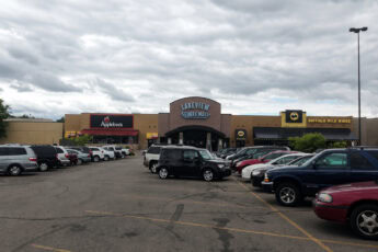 Parking lot in front of Lakeview Square Mall with stores and cars.