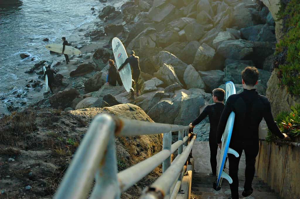 Father and Son, down steps to water winter, with surf boards, wet suits, Santa Cruz, California, USA