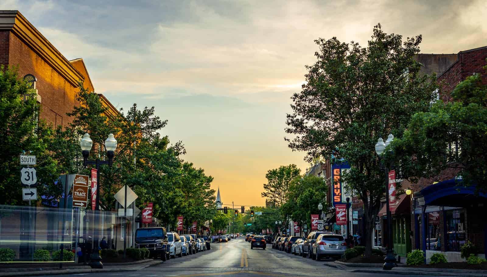 landscape photography of vehicles parked on side of a street